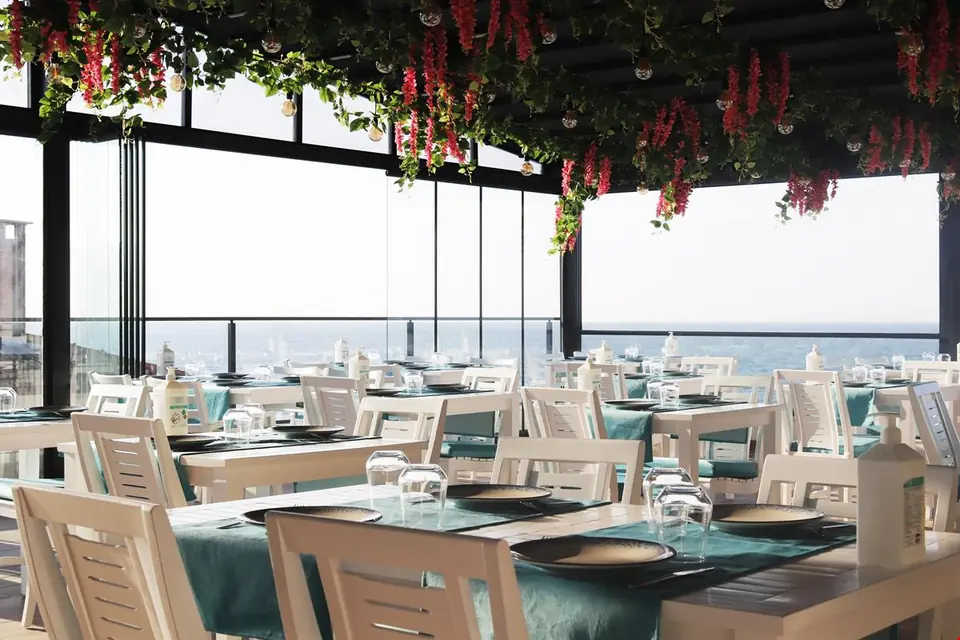 Çatı katındaki restoranda deniz manzaralı masalar